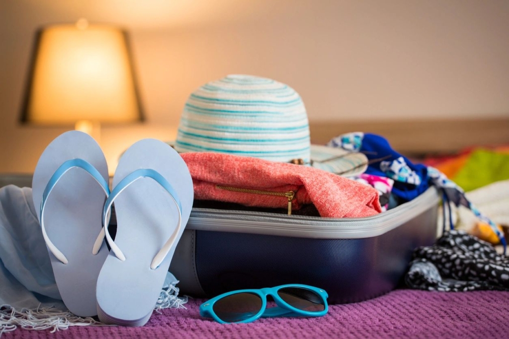 Pool accessories in a suitcase siting on a bed